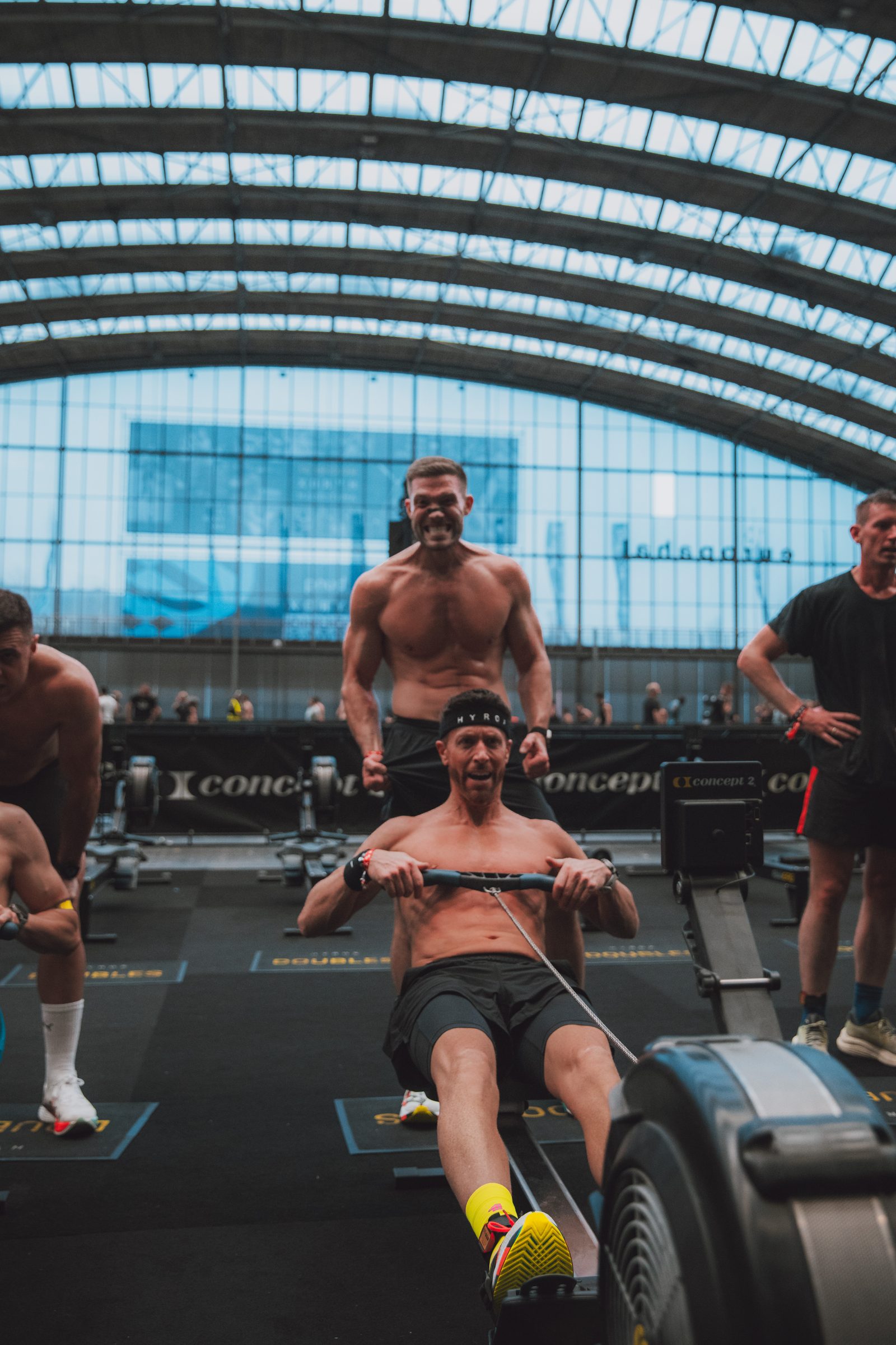 Rowing under the arched glass roof while a teammate roars him home.