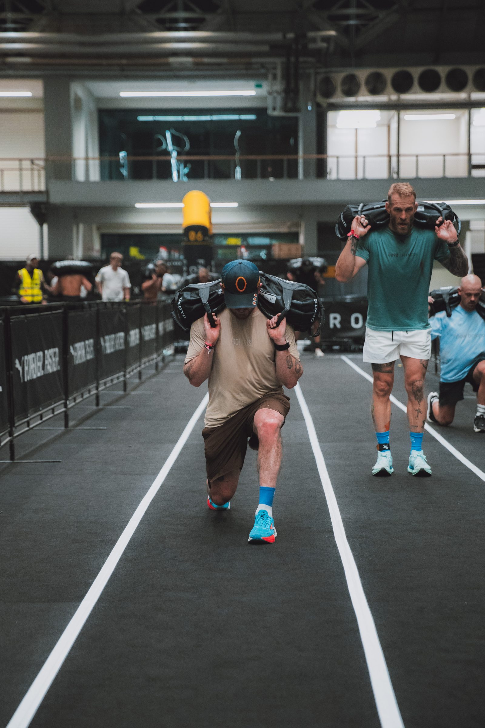 Sandbag lunges up the lane, a second athlete grinding behind.