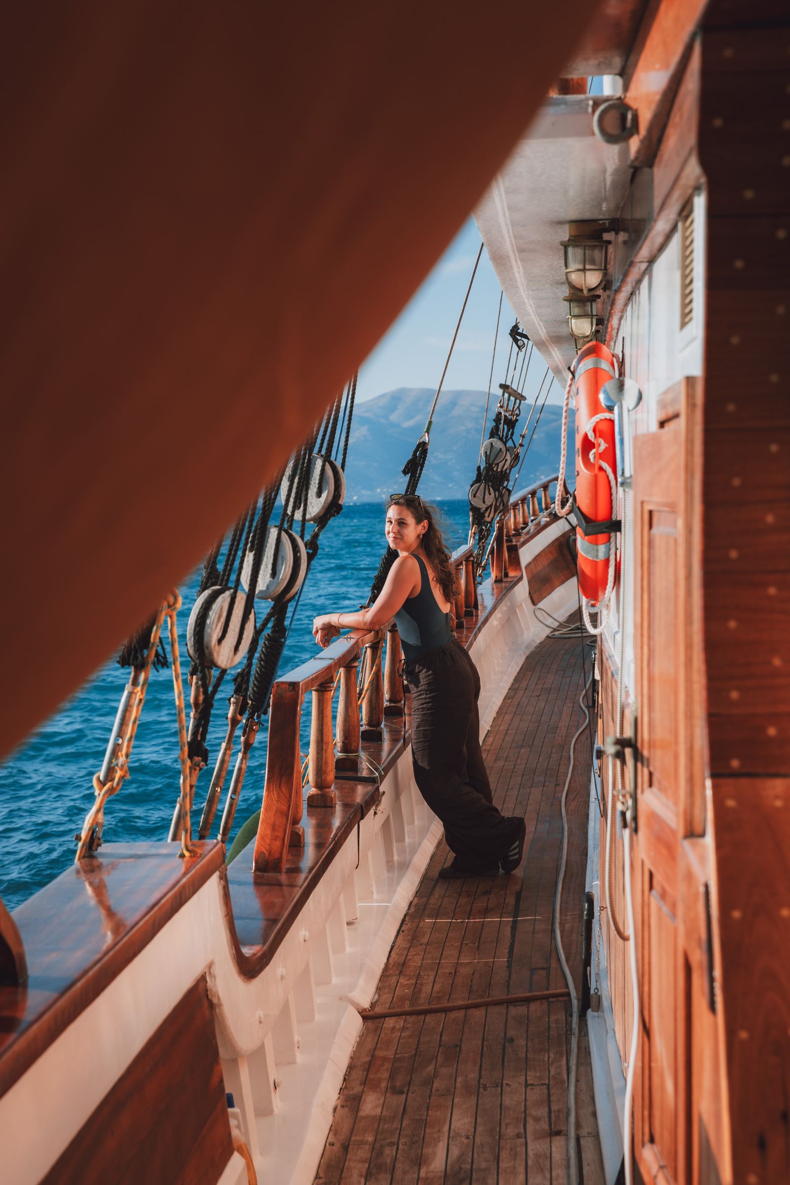 Leaning on the rail of a wooden gulet, deep blue Ionian Sea below.