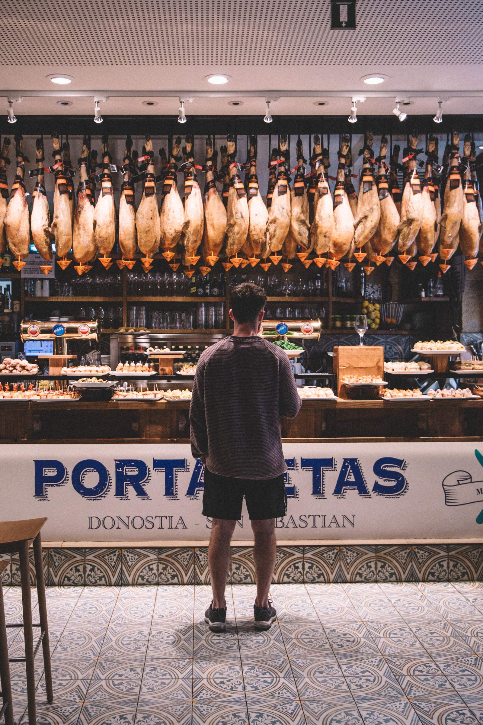 Choosing pintxos under a ceiling of jamón, Donostia-San Sebastián.
