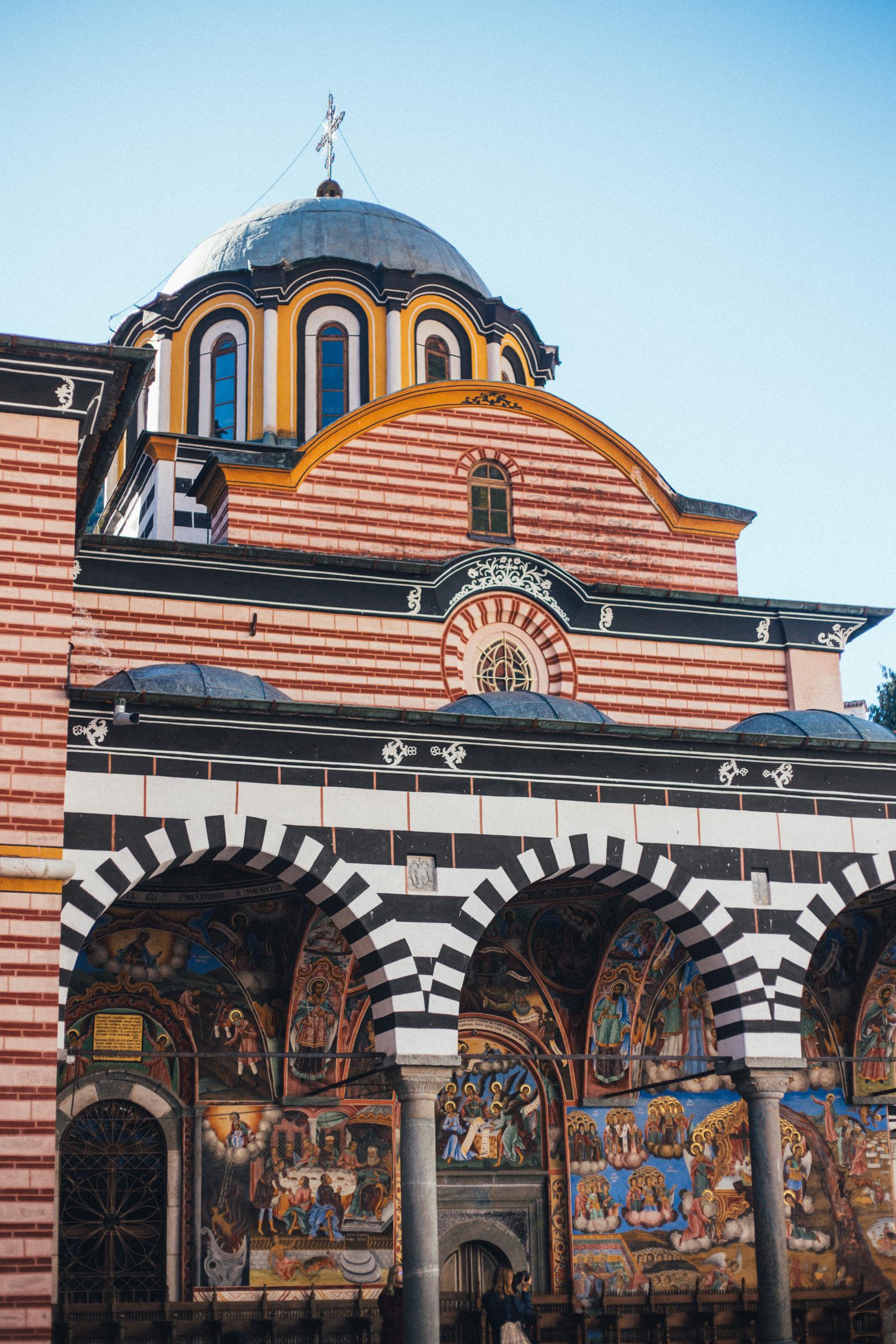 The striped arches and frescoes of Rila Monastery, Bulgaria.